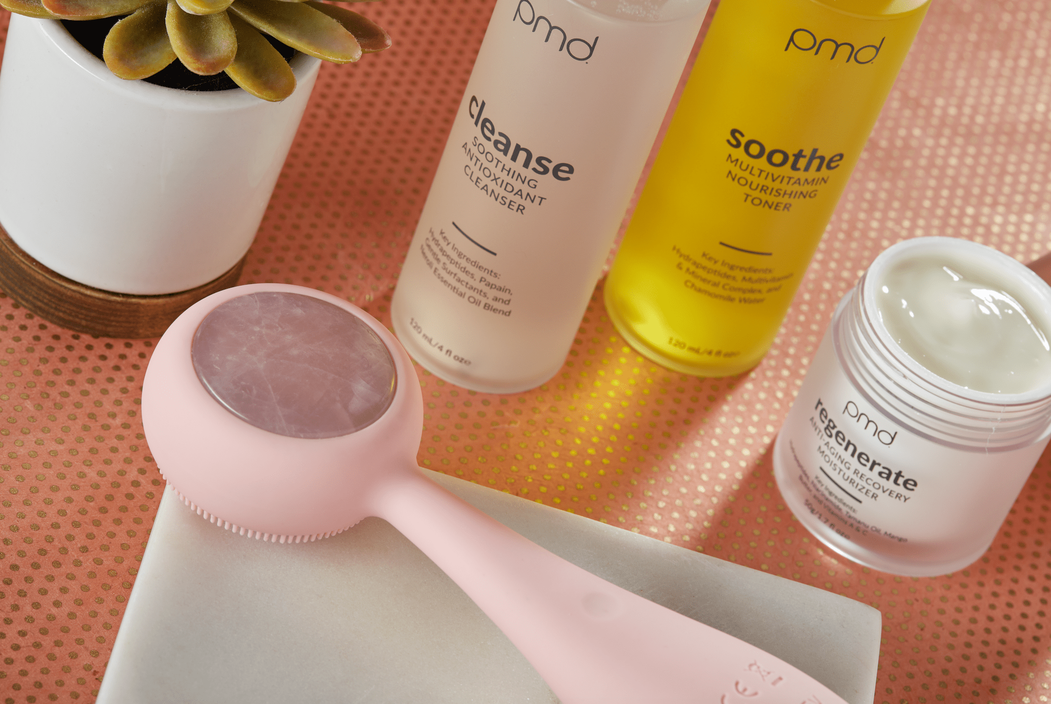 PMD Beauty Clean device, Cleanse Soothing Antioxidant Cleanser, Soothe Multivitamin Toner, and Regenerate Anti-Aging Moisturizer displayed together, showcasing a complete at-home skincare routine for cleansing, soothing, treating, and moisturizing.