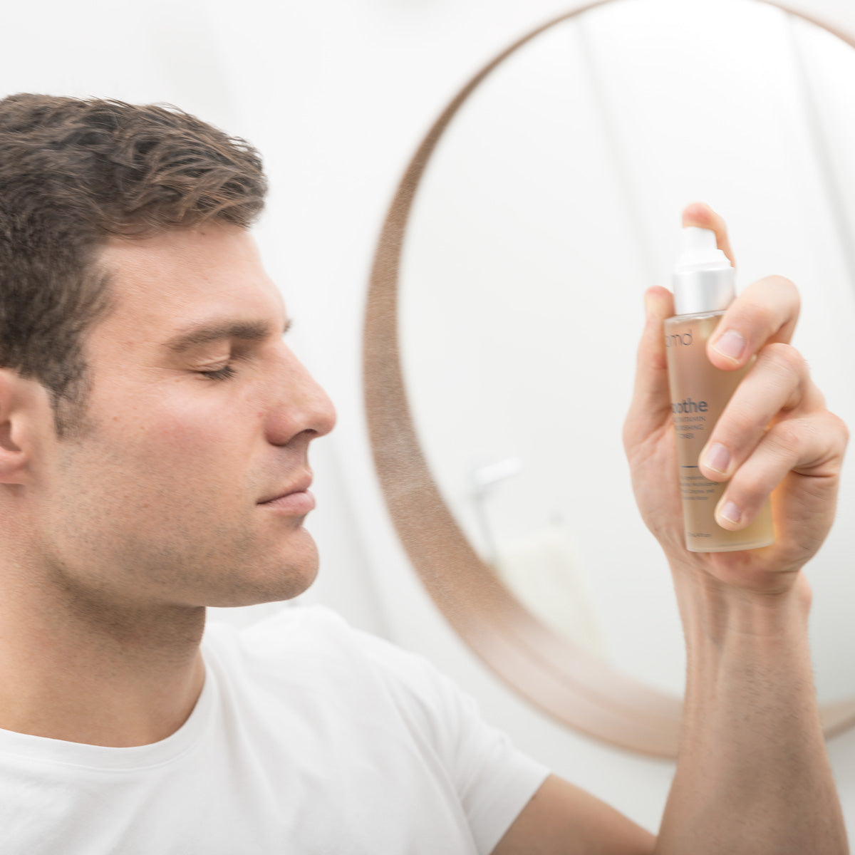 Man spraying toner on face