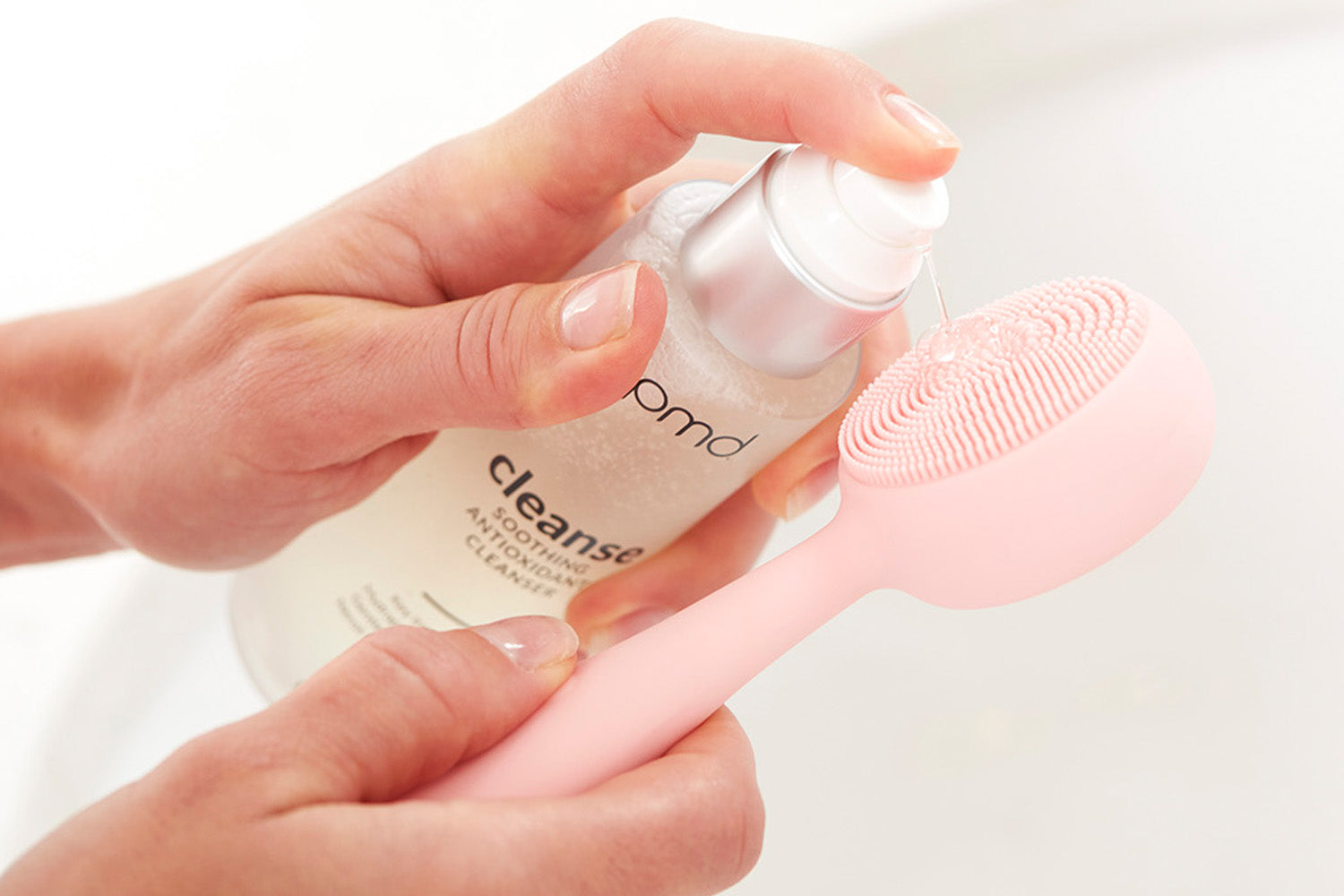 woman putting cleanser on PMD Clean