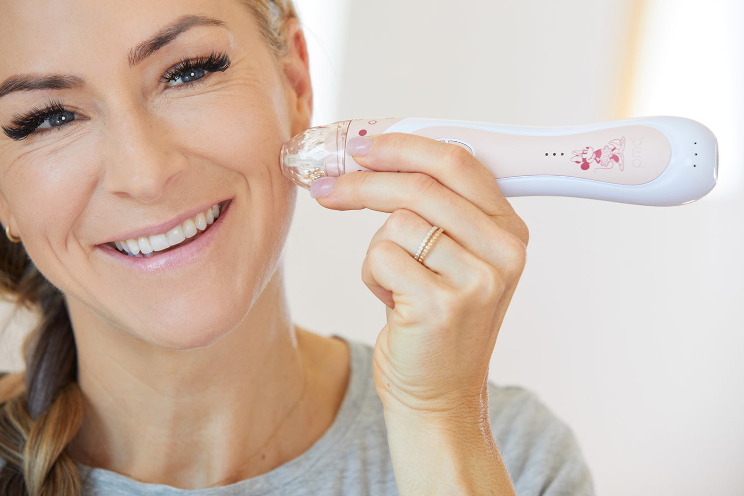 woman using personal microderm to exfoliate her face.