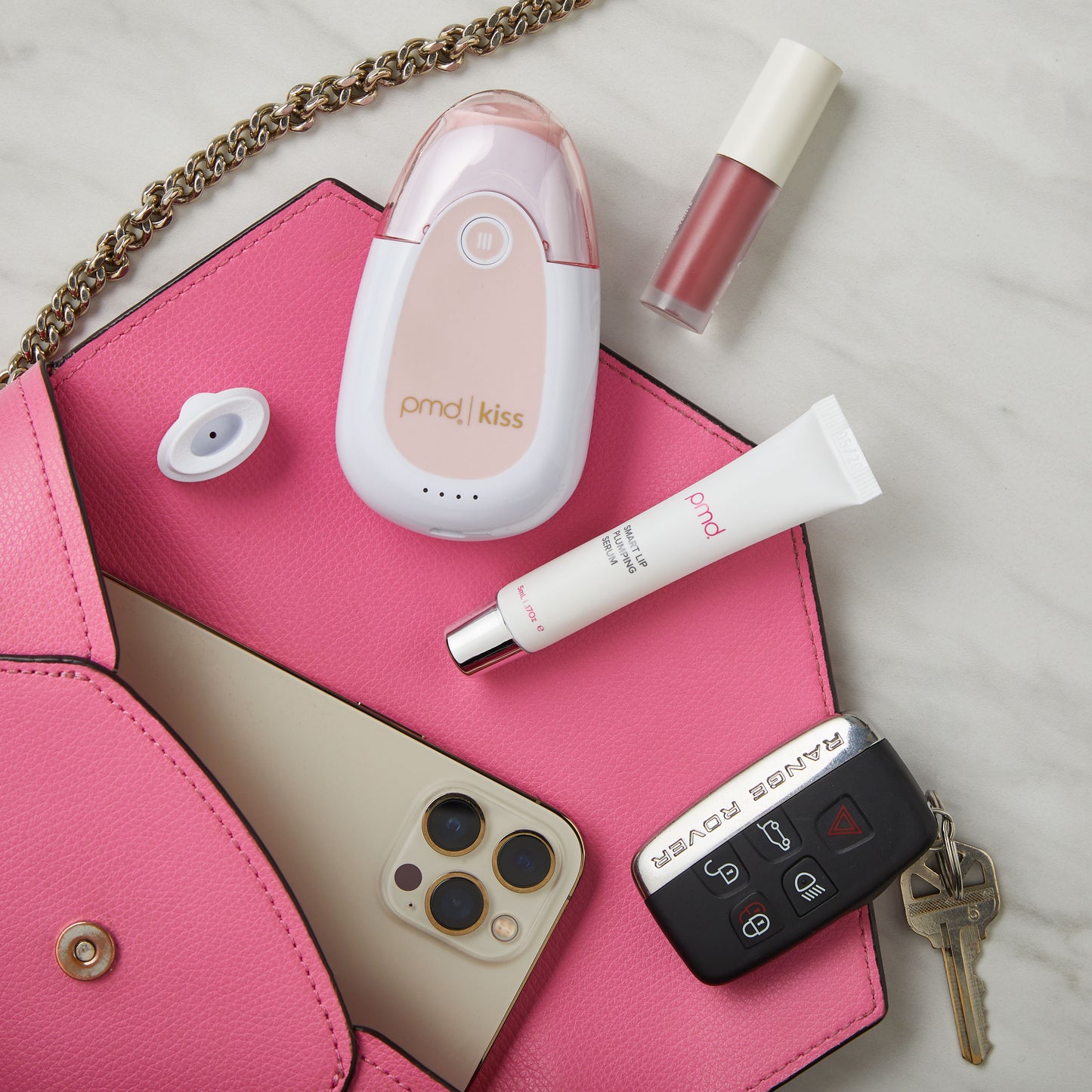 3102?PMD Kiss surrounded by kissfoliators, purse, car keys, phone and lip serum
