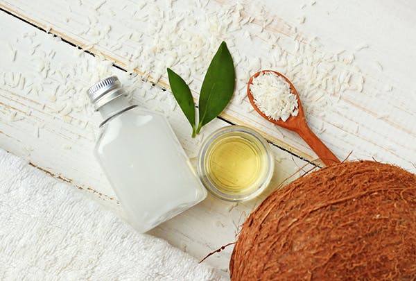 Coconut oil with coconut and rice on table