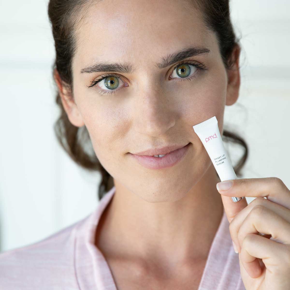 woman holding smart lip plumping serum