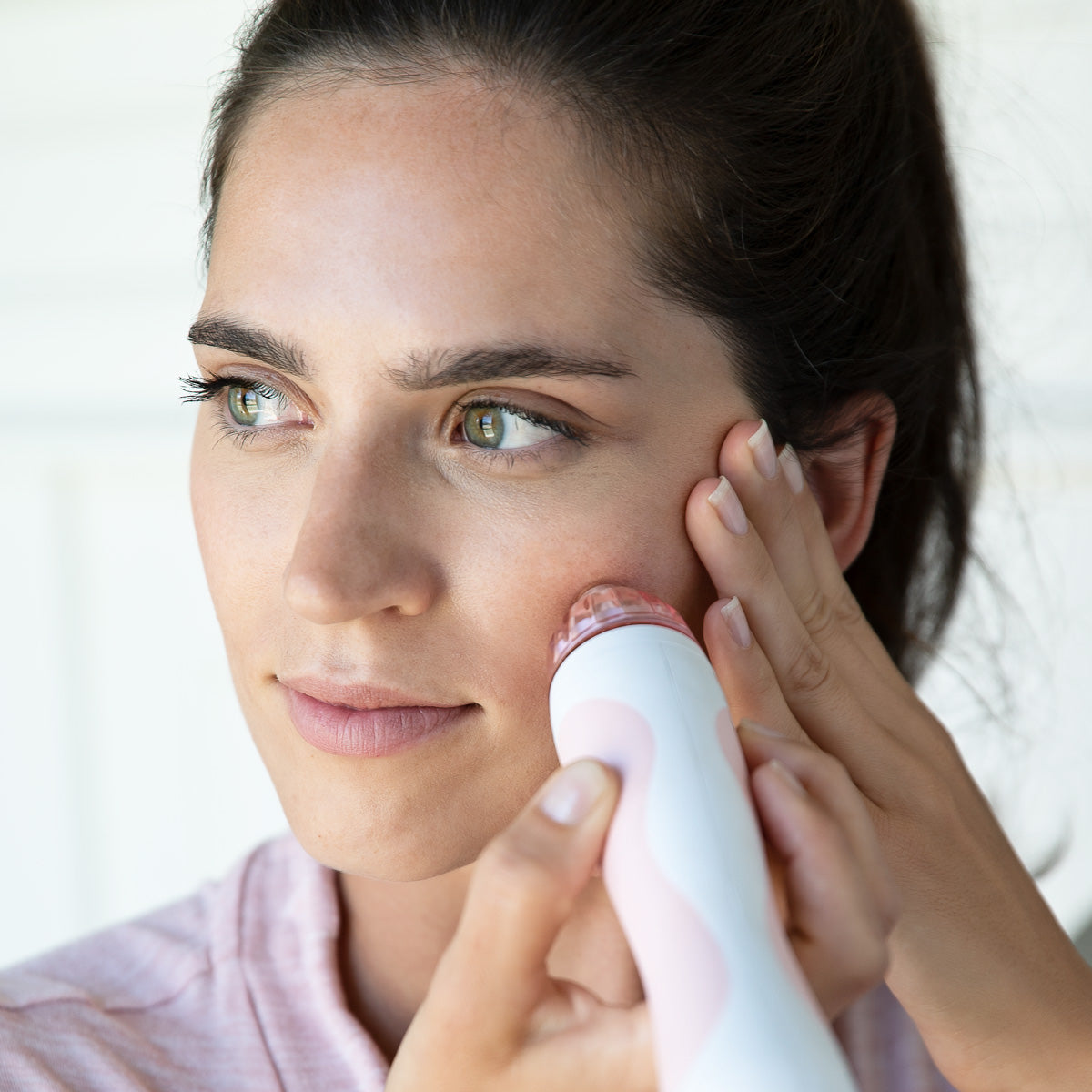 woman using personal microderm on face