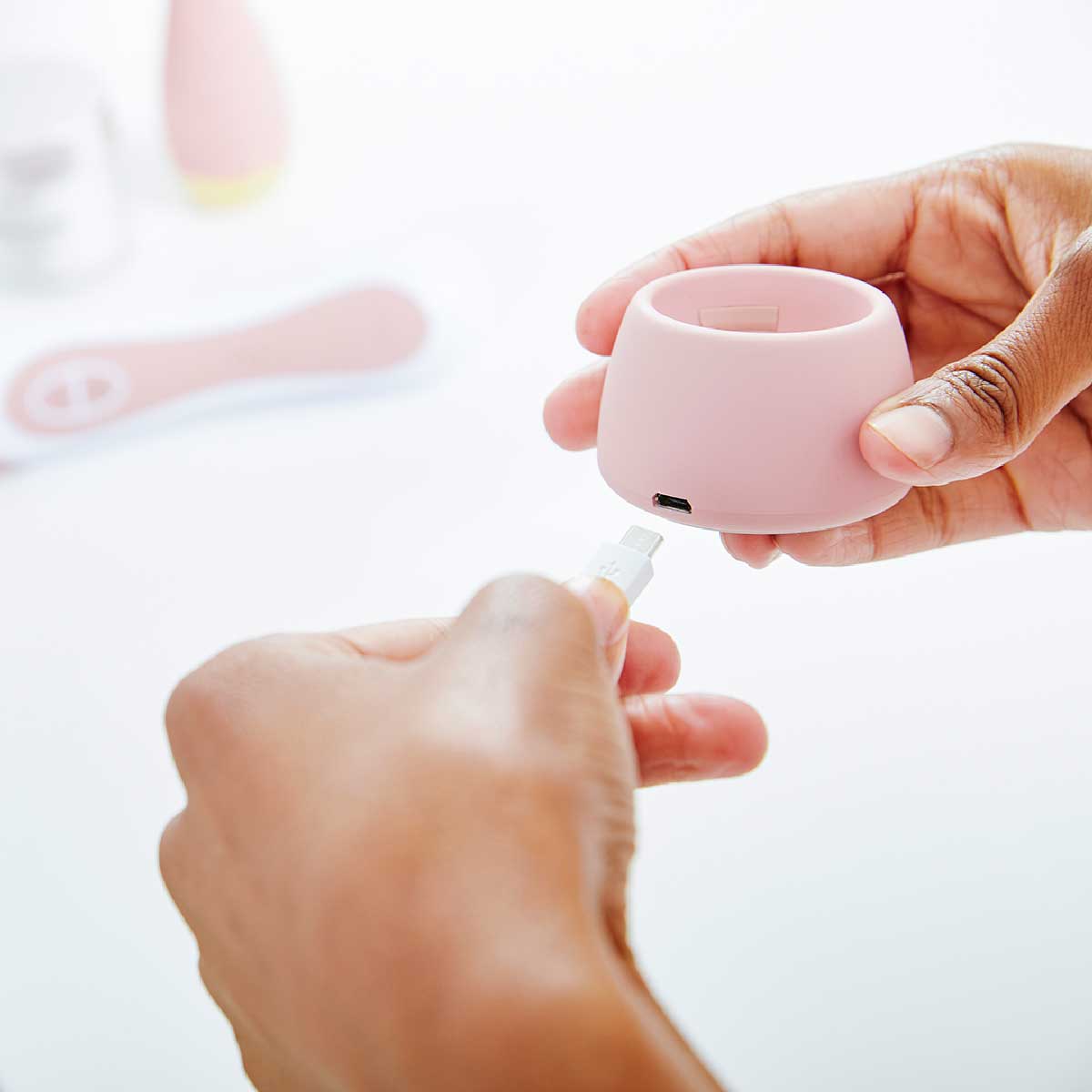 woman inserting charging cord into base