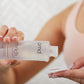 woman pouring enrich essence onto a cotton pad