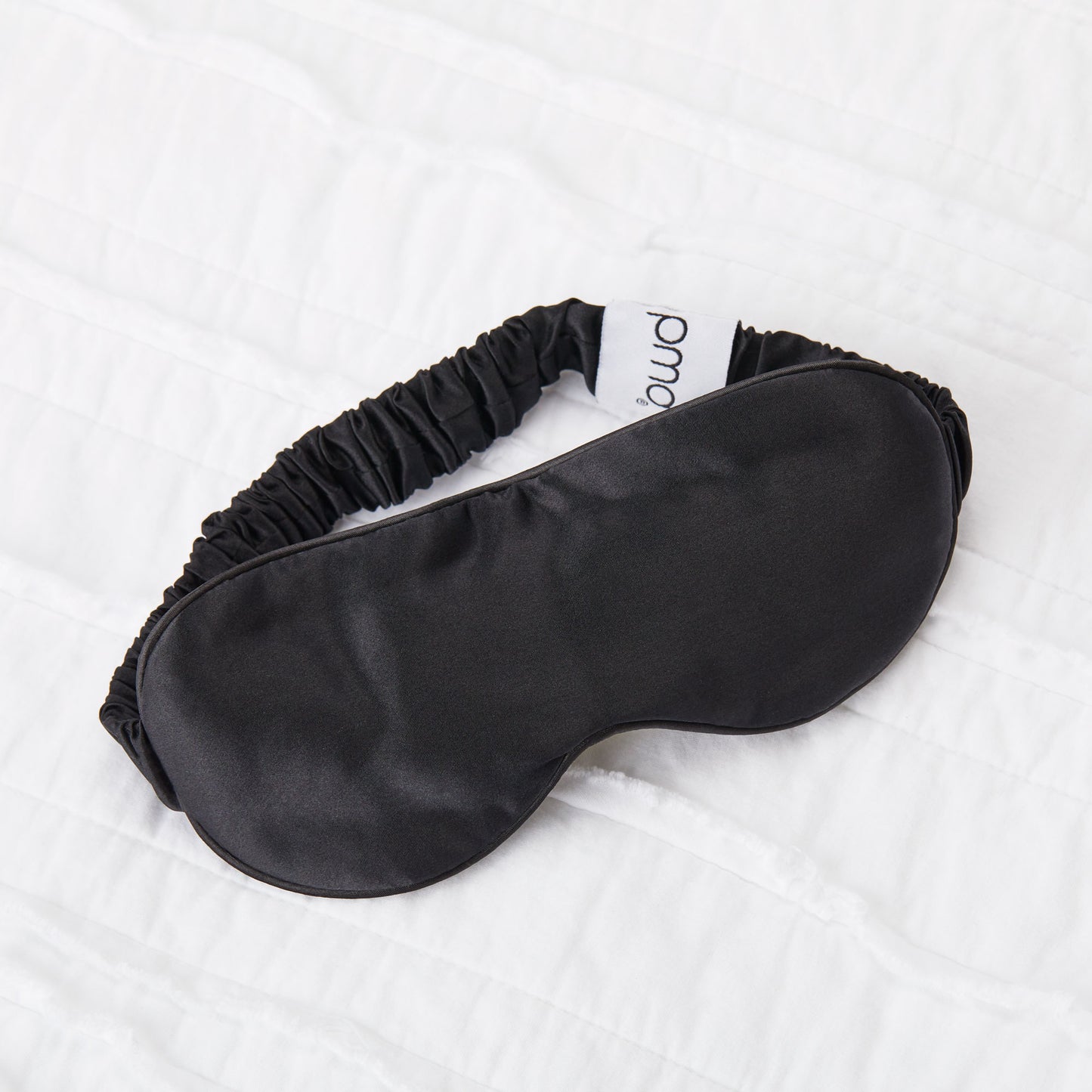 5008-SMBLACK?Silversilk sleep mask in black on bed