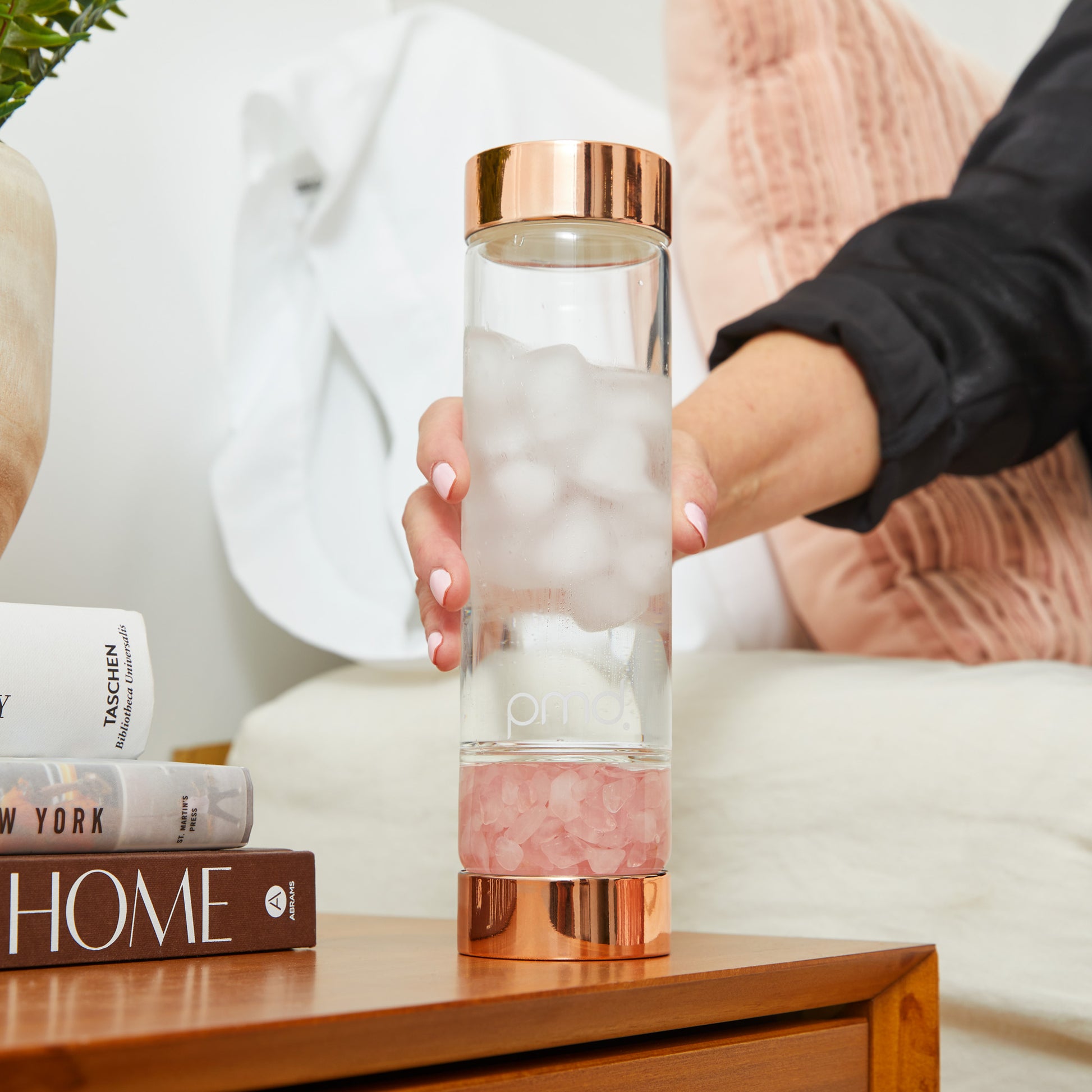 5012-RQ?Woman reaching for PMD Aqua Water Bottle on nightstand