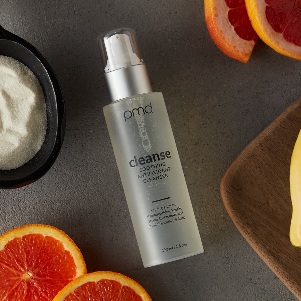 1021-N?cleanse Soothing Antioxidant Cleanser laying with fruit on slate counter